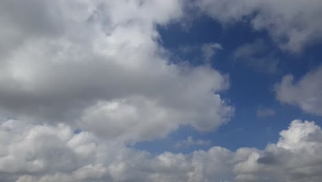 Blauer-Sommerhimmel-Mit-Dichten,-Dicken-Regenwolken,-Die-Sich-über-Den-Himmel-Bewegen