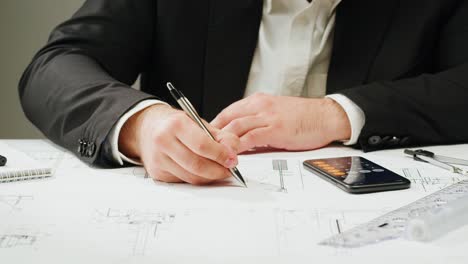 professional working on blueprints with a smartphone calculator