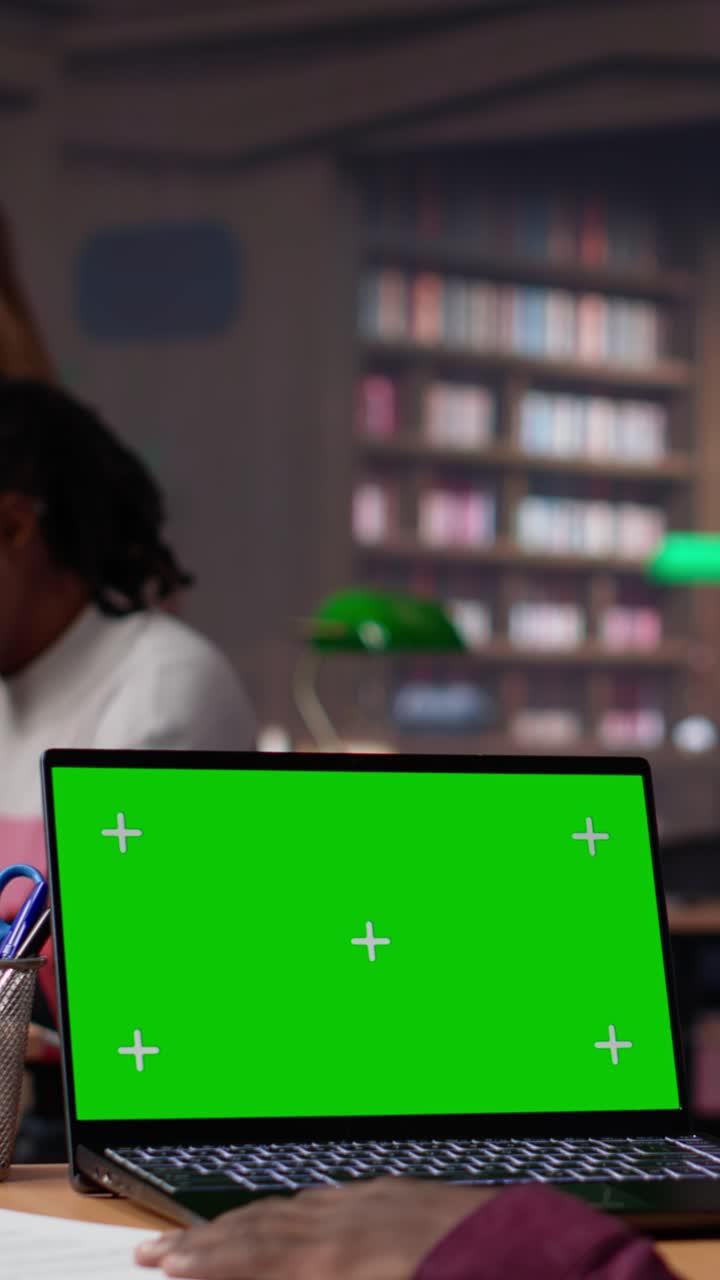 Vertical video college student looks at a copy space on laptop while collecting notes