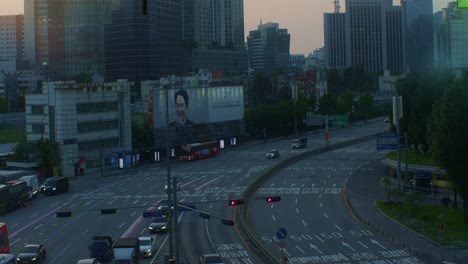 South-Korea-Seoul-city-town-centre-urban-traffic-road-with-cars,-buses-and-crowded-places-in-the-evening-with-buildings-skyscrapers-and-billboards-high-angle-viewpoint