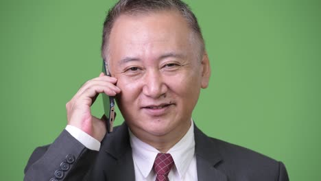 mature japanese businessman using phone