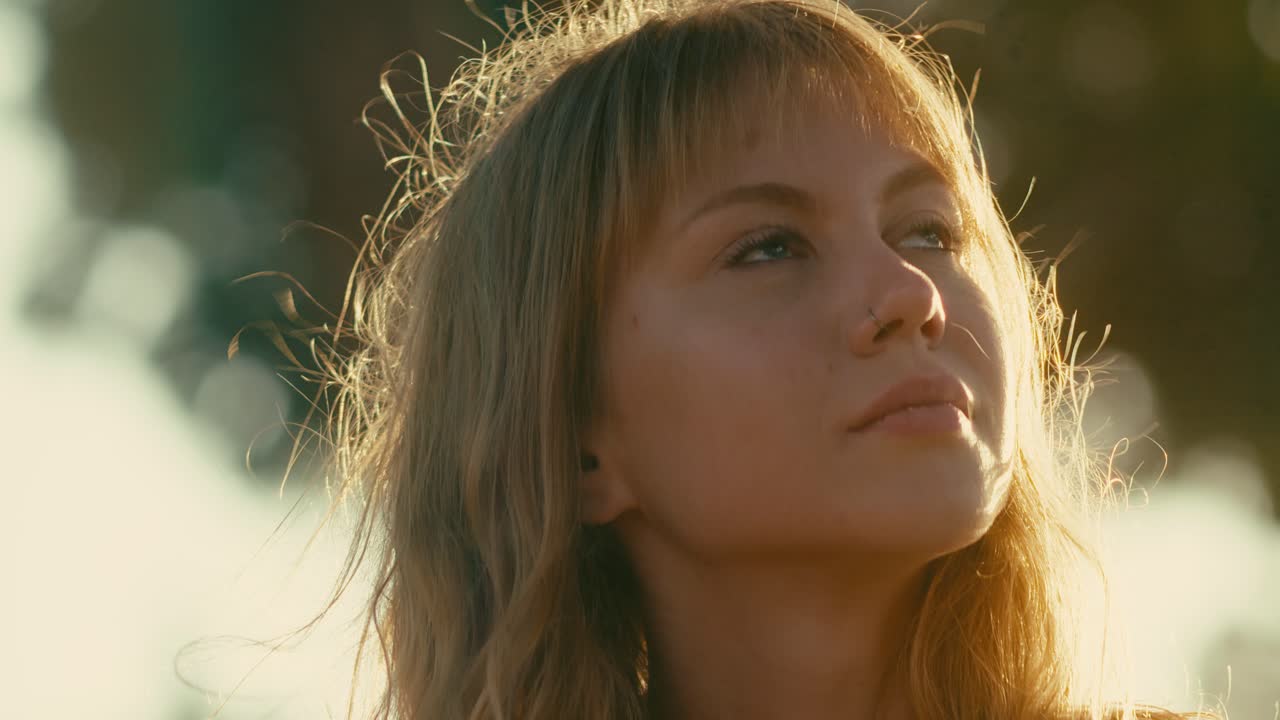 예쁜 백인 소녀 바람에 느슨한 머리카락 해가 지면 빛나는, 얼굴에 초점을 맞추