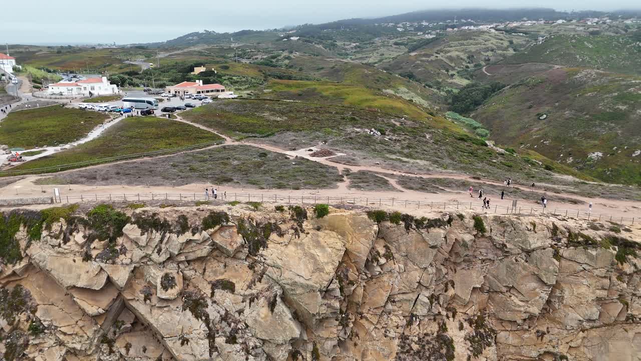 Scenic cliffside landscape with mountains and town in the background