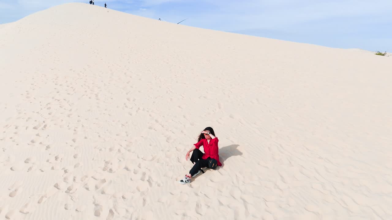 Aerial View of a Girl Sitting on the Hill in the Desert.