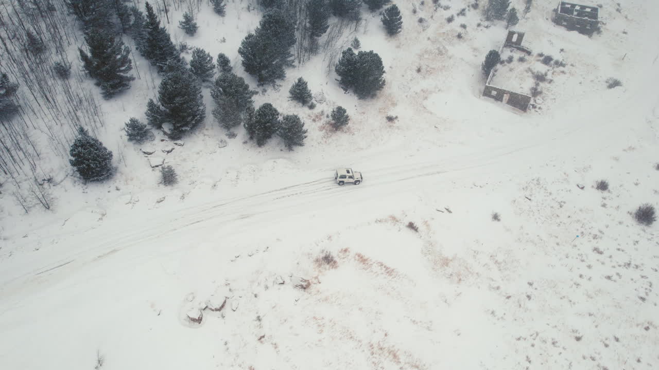 vista aérea de drones de land rover defender d90 suv estacionado en un camino forestal alpino cubierto de nieve en montañas rocosas cerca de nederland boulder colorado usa durante fuertes nevadas