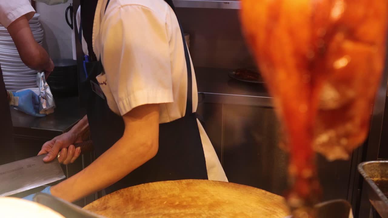 chef cortando carne de cerdo crujiente en una cocina