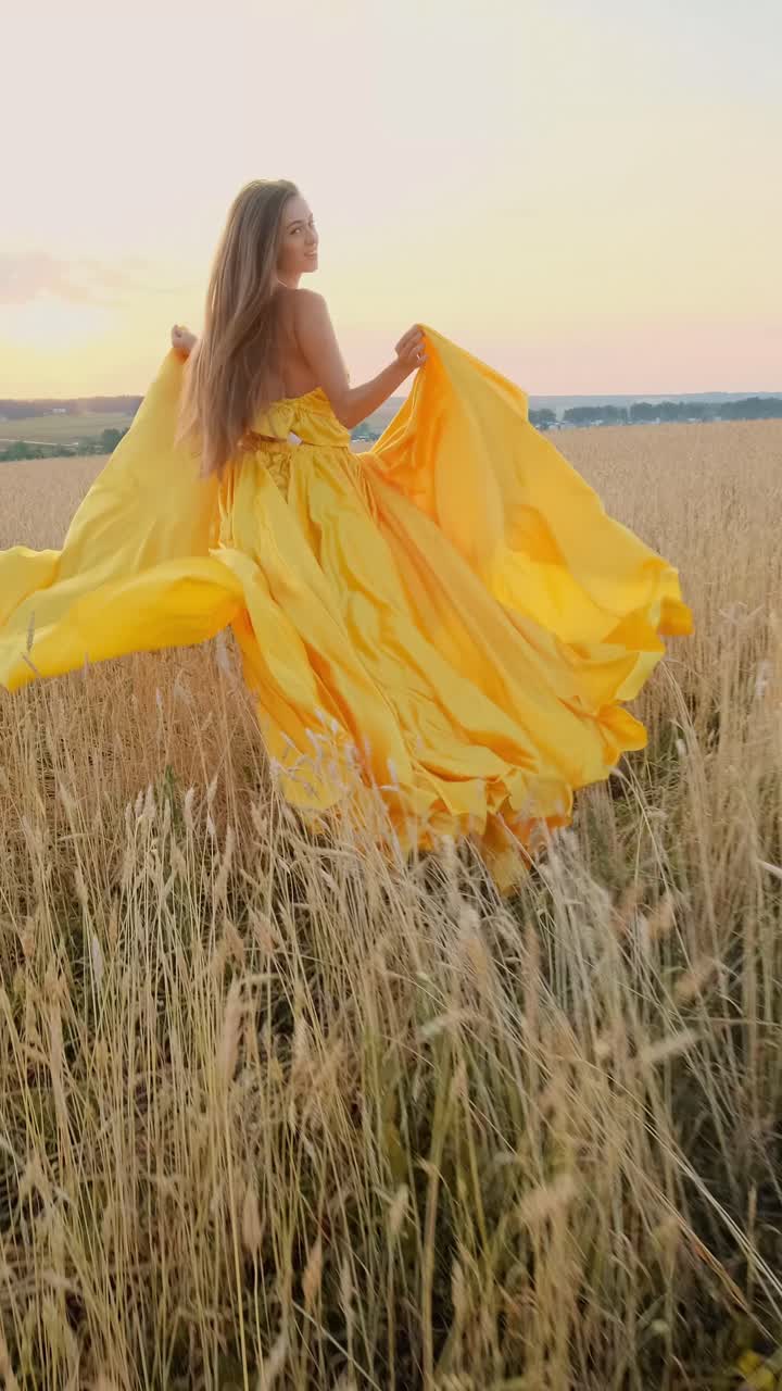 Woman in a Yellow Dress in a Wheat Field at Sunset
