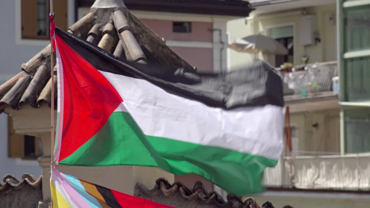 A Palestinian flag with a small hole flutters in the wind
