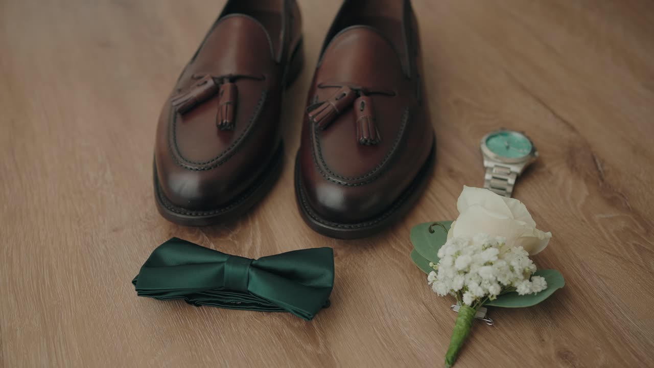 Leather shoes bow tie watch and flower arranged on wooden floor