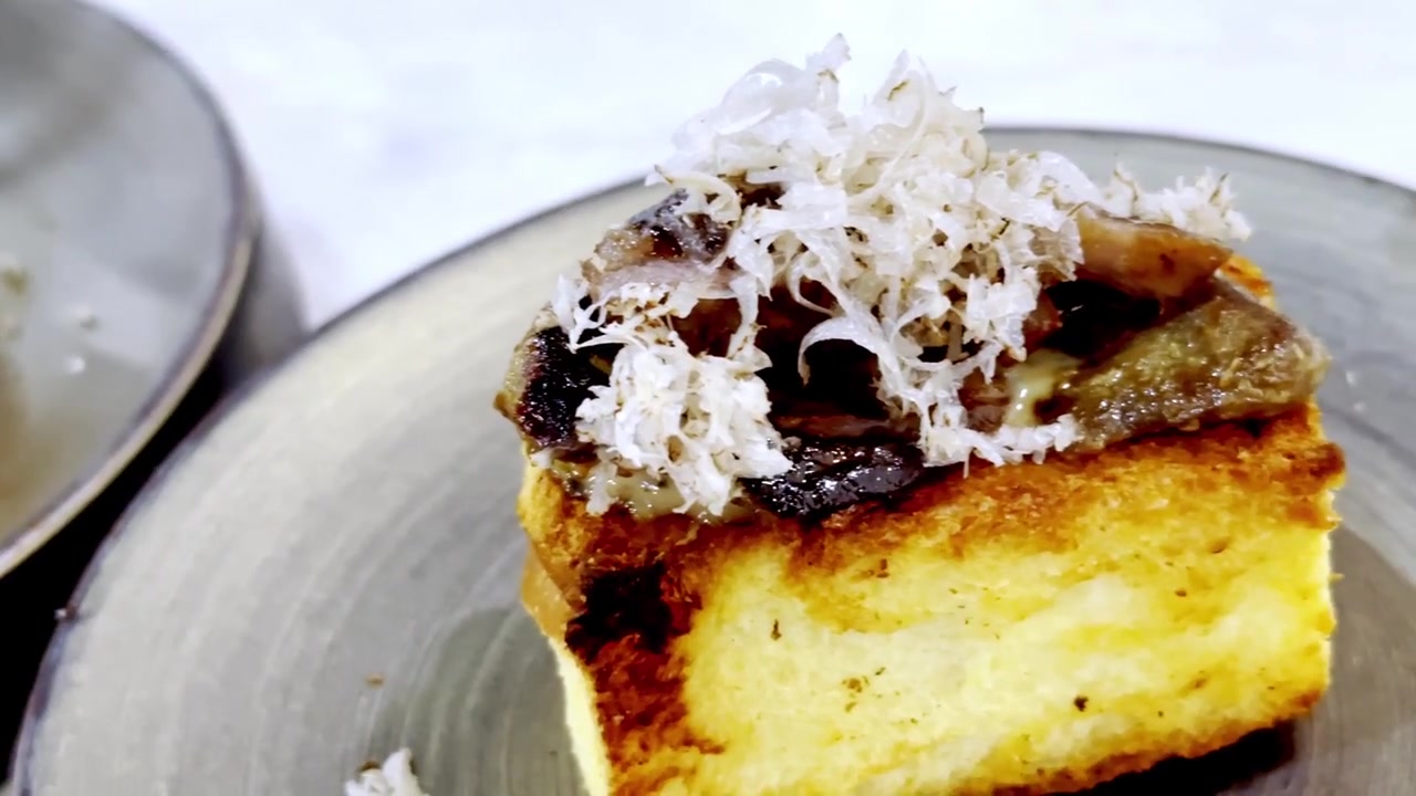 Primer plano de foie gras sellado a la sartén, servido sobre pan tostado y cubierto con láminas de trufa negra, presentado como un lujoso aperitivo gourmet