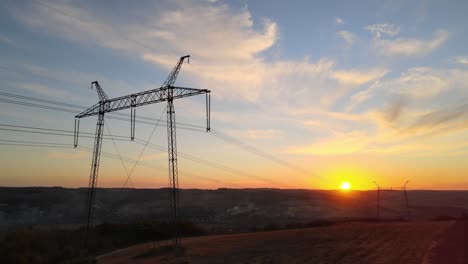 dark silhouette of high voltage tower with electric power lines at sunrise. transmission of electric energy concept