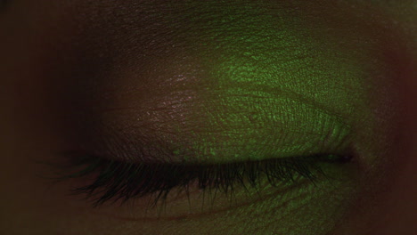 close up macro eye multicolor light flashing on iris club concept