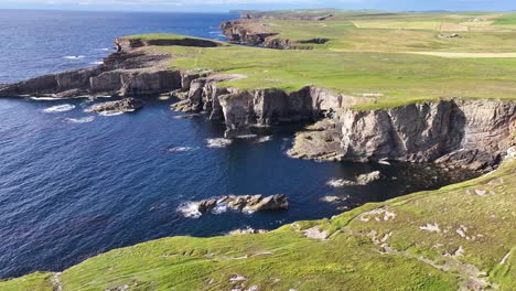 Landscape-and-Coastline-of-Scotland-UK,-Aerial-View-of-Pastures-and-Cliffs-Above-Sea-on-Sunny-Day-60fps