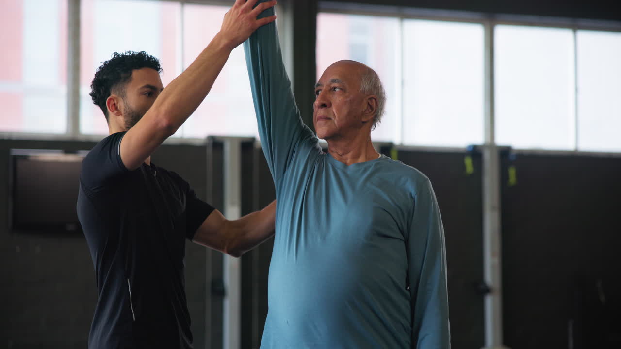 Senior Man Training With His Personal Trainer In The Gym