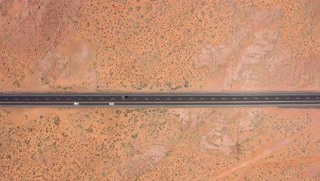 aerial drone footage of cars driving on road in the middle of the desert in arizona, usa
