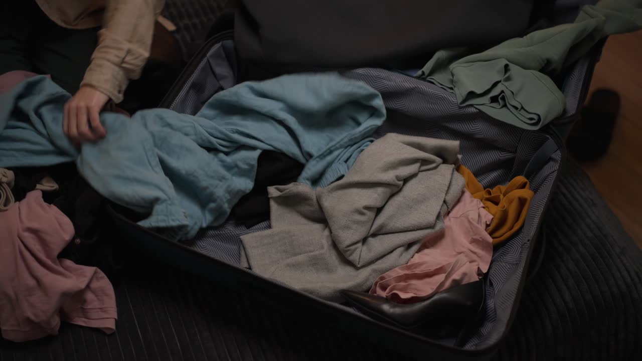 Packing a suitcase with clothes