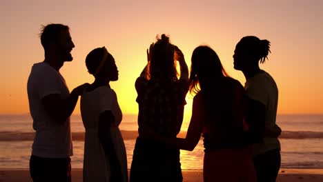 young adult friends taking selfies on the beach at sunset 4k