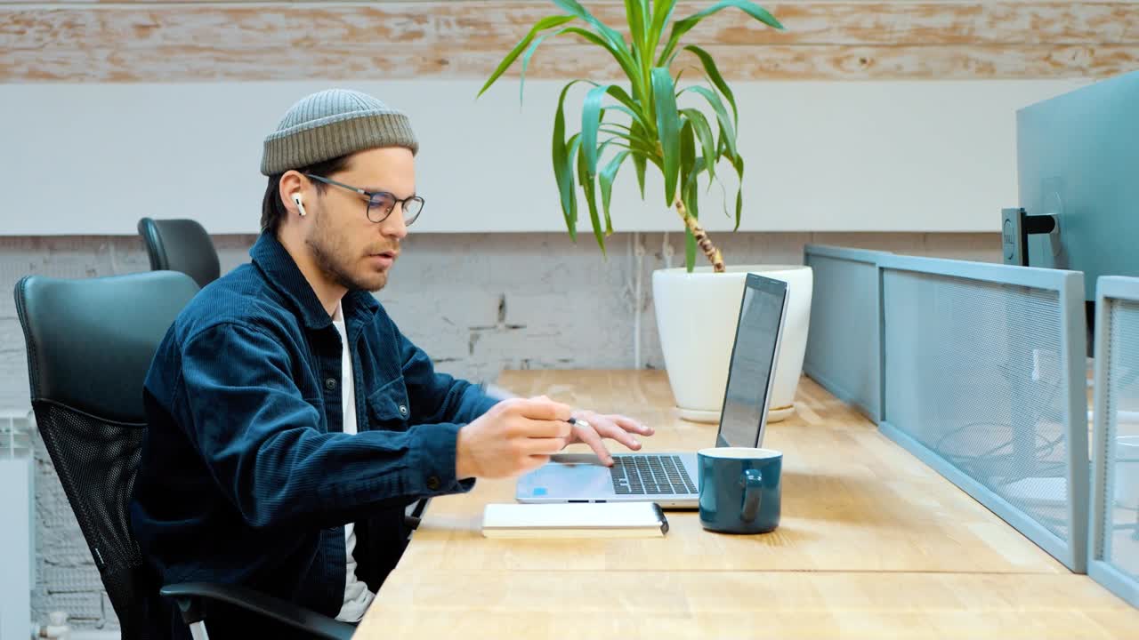 집 사무실 스튜디오에서 책상에 앉아 노트북으로 타이핑하는 직업적인 창의적인 남자, 컴퓨터를 사용하는 젊은 남성 전문, 바쁜 노동자, 프리랜서