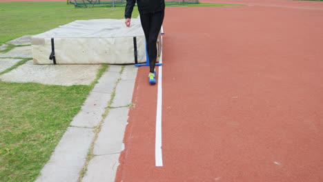 low section of female athlete measuring high jump field with footstep 4k