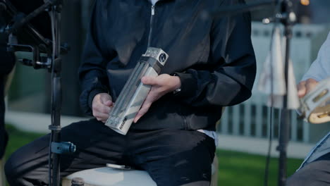 Close-up-of-a-musician-playing-a-guiro-during-an-outdoor-performance