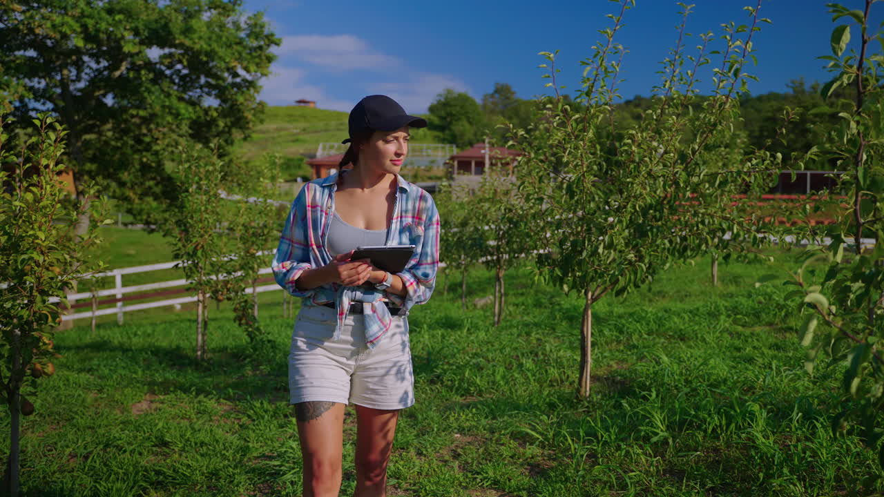mujer agricultora usando tableta en el huerto