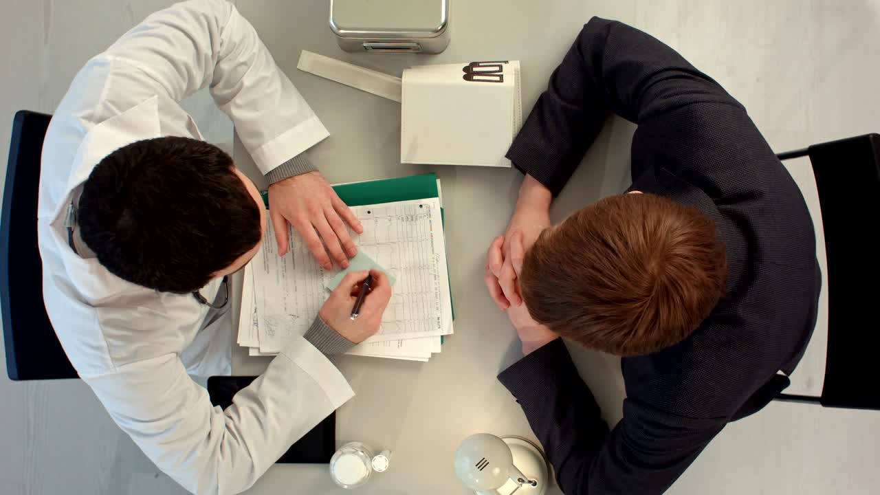 Doctor writes the value to patient with big price. Top view