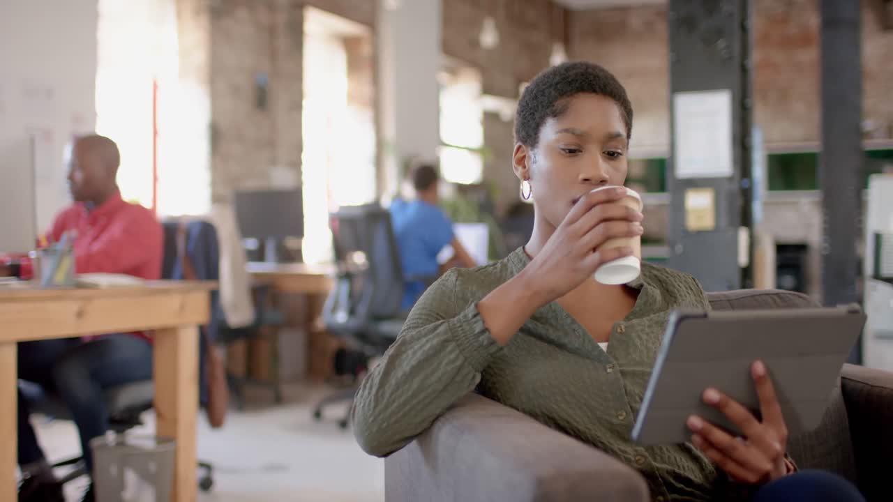 colegas afroamericanos usando computadora y tableta en la oficina creativa, en cámara lenta