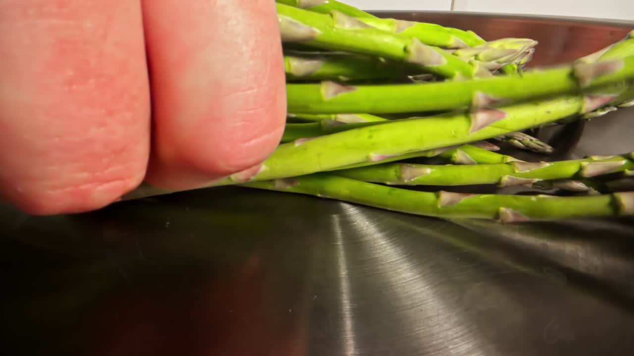 Fresh asparagus in a shiny pan ready for a delicious meal prep