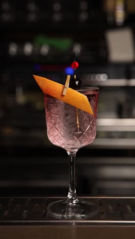 close-up of a cocktail garnish being placed on a cocktail