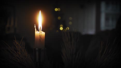 a single lit candle in a cozy warm environment at christmas time
