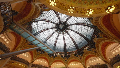 Beautiful-ceiling-inside-the-Galeries-Lafayette-with-golden-walls-and-glass-dome,-in-Paris,-France