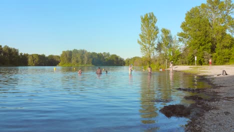 people swimming in the lake at the grand parc de miribel-jonage in lyon, france.