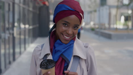 portrait shy young african american woman laughing enjoying successful urban lifestyle beautiful black muslim female wearing traditional hijab headscarf in city holding coffee