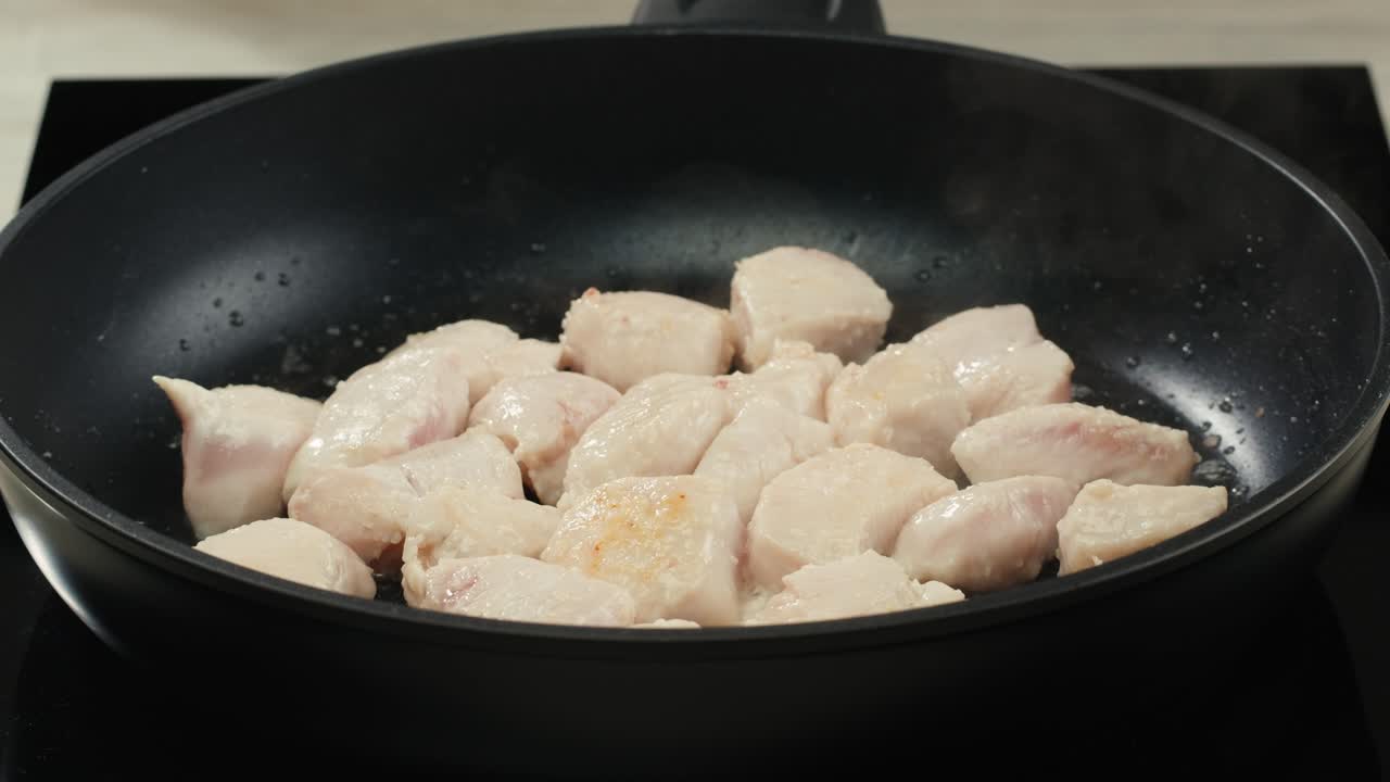 Man slicing raw turkey or chicken meat fillet on oak cutting board closeup, cooking with knife on restaurant kitchen. High quality 4k footage