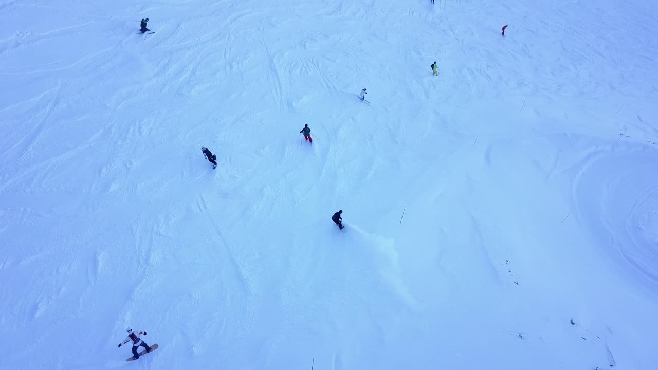 vista aérea de esquiadores y snowboarders en las laderas