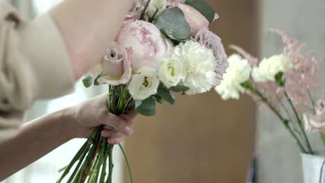 young florist assembles a rustic wedding bouquet