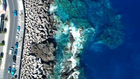 aeriel drone footage at garachico - caleton (tenerife) next to the blue ocean as the waves hit the rocks in the water