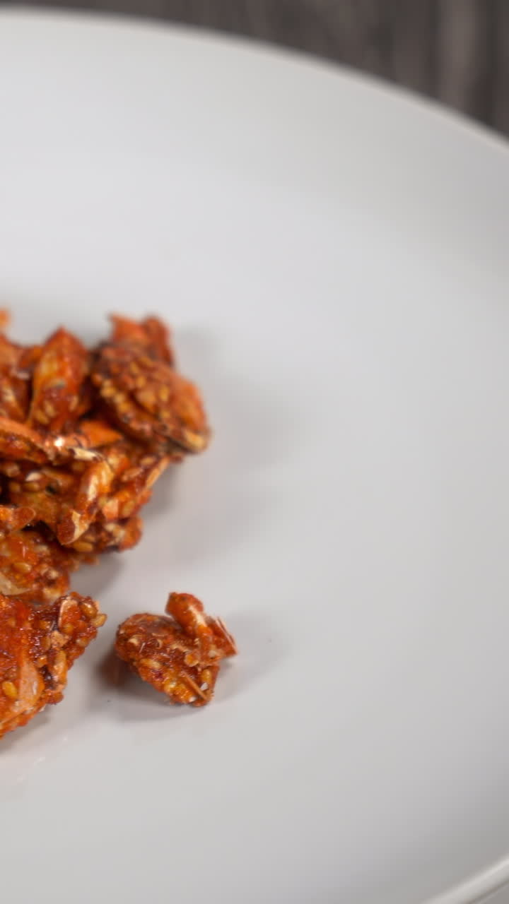 Appetitosi granchi fritti croccanti con semi di sesamo su piatto bianco