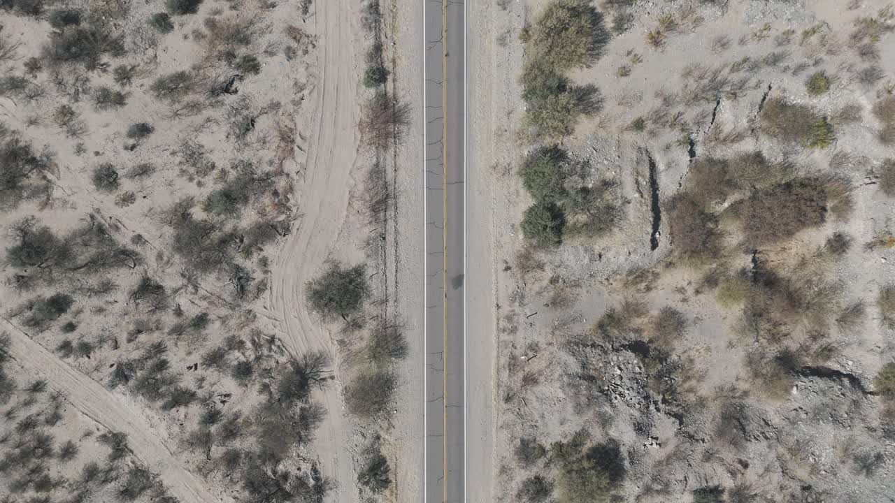 Aerial view of vehicle traveling along tourist route 40 in arid Cafayate valley. Salta, Argentina.