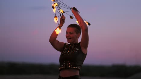 professional dancers women make a fire show and pyrotechnic performance at the festival with burning sparkling torches.