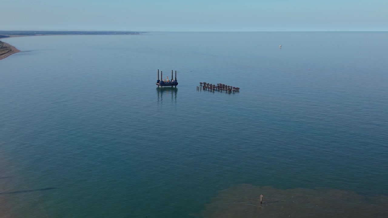 Luftfoto af jackup-pram og offshore-struktur i rolige kystfarvande, Suffolk, Storbritannien.