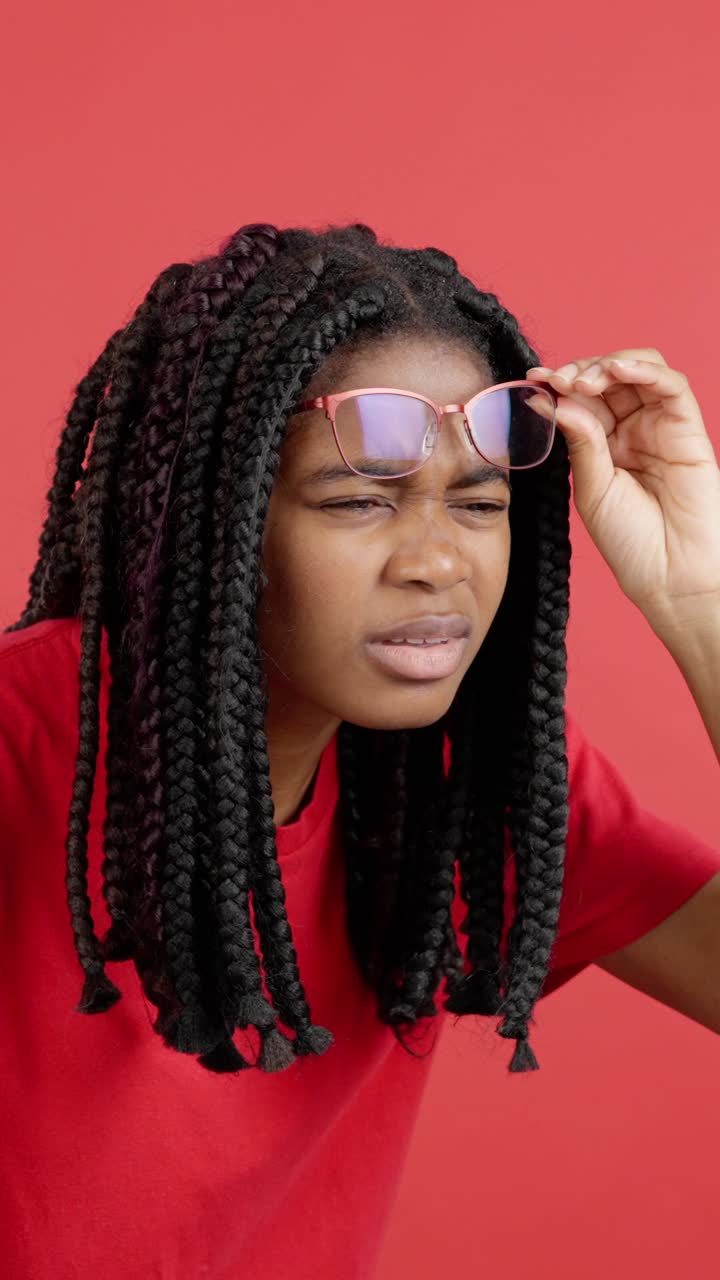 Donna con trecce e occhiali su sfondo rosso