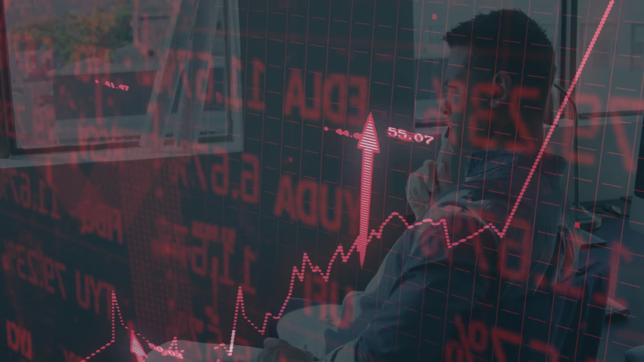 Analyzing financial data, businessman with red graphs and numbers overlay in office
