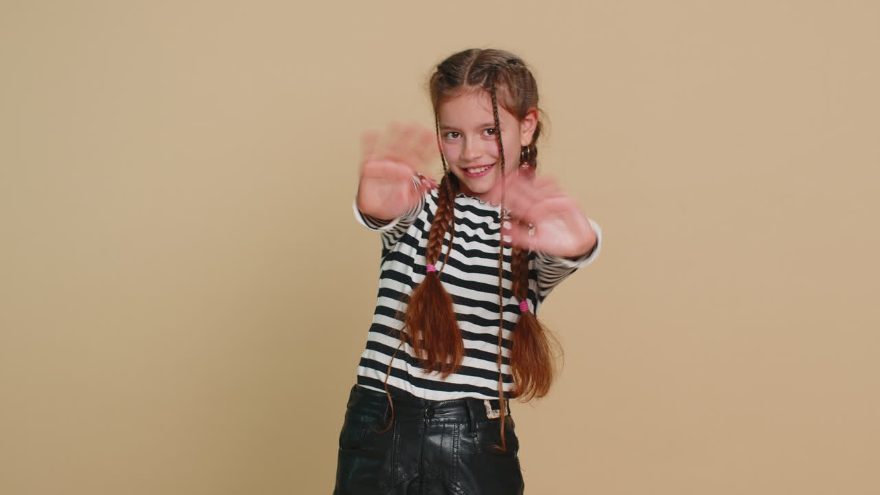 Young cute school girl kid smiling friendly gesturing hello or goodbye welcoming waving hands