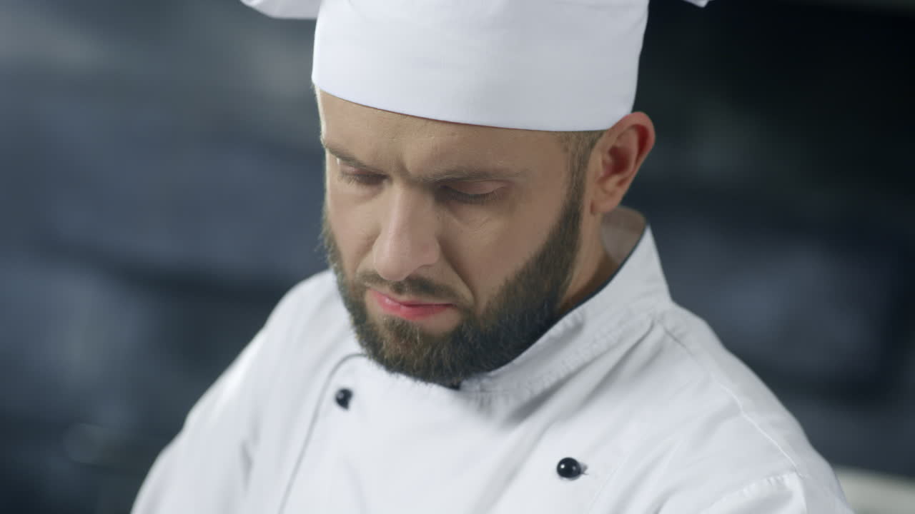 Chef che lavora in una cucina professionale. Primo piano del volto dello chef mentre cucina.