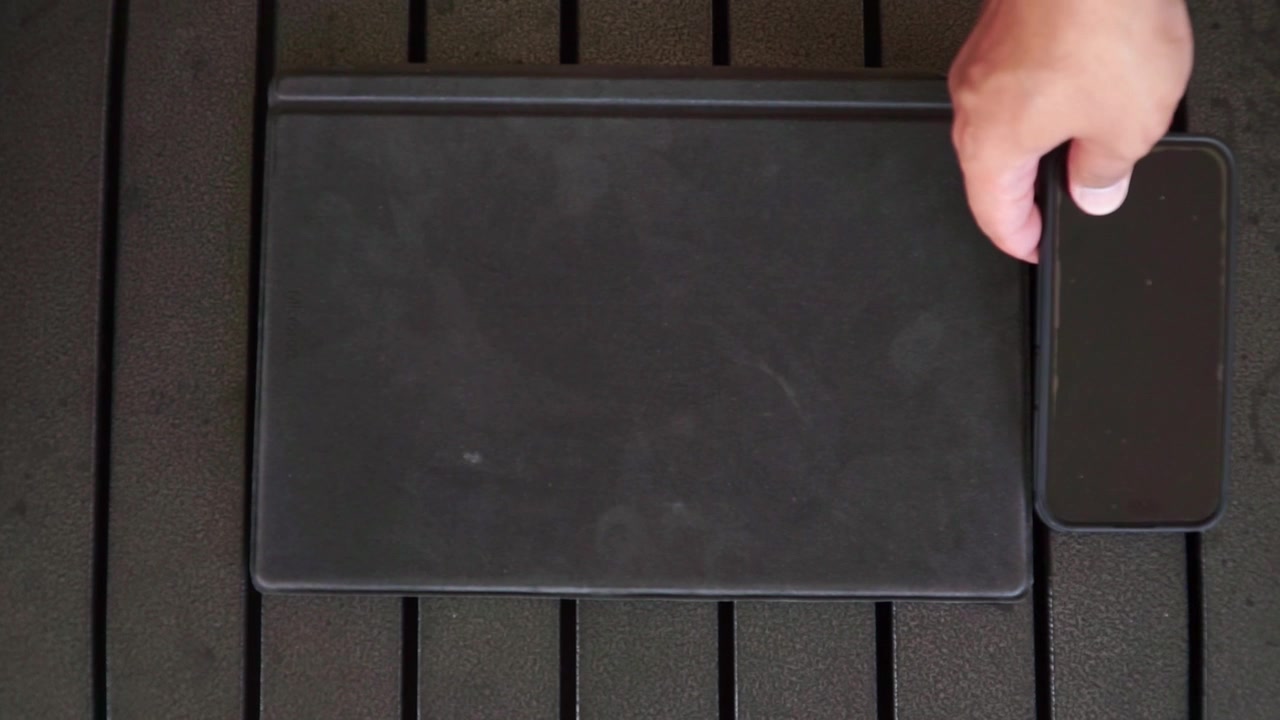 Ruka pokládající tablet a chytrý telefon na stůl, koncept moderní technologie a uspořádání pracovního prostoru.