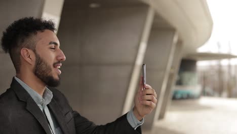 side view of smiling young man talking on smartphone