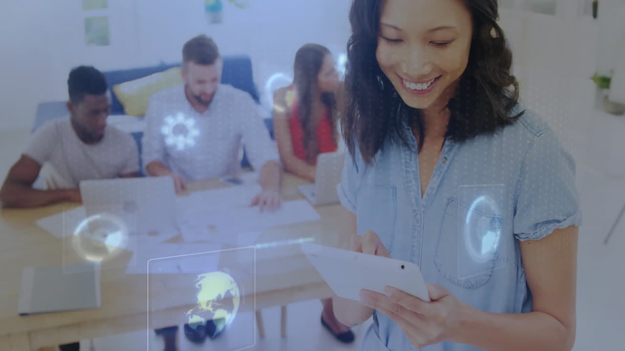 Using tablet with digital data animation, woman smiles with colleagues working behind