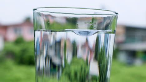 droplets of water creating bubbles in a glass filled with clean and clear water