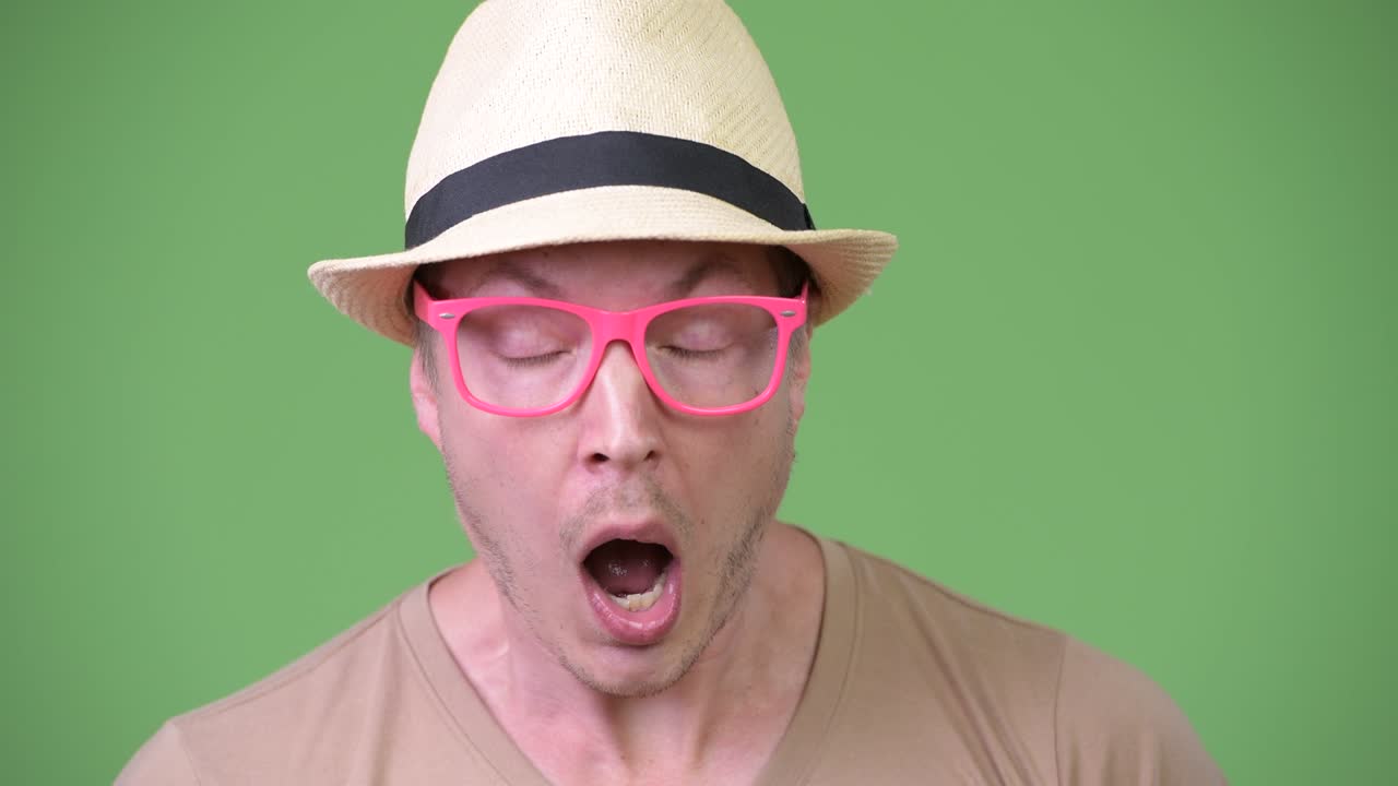 젊은 잘생긴 관광객이 충격을 받고 있습니다.